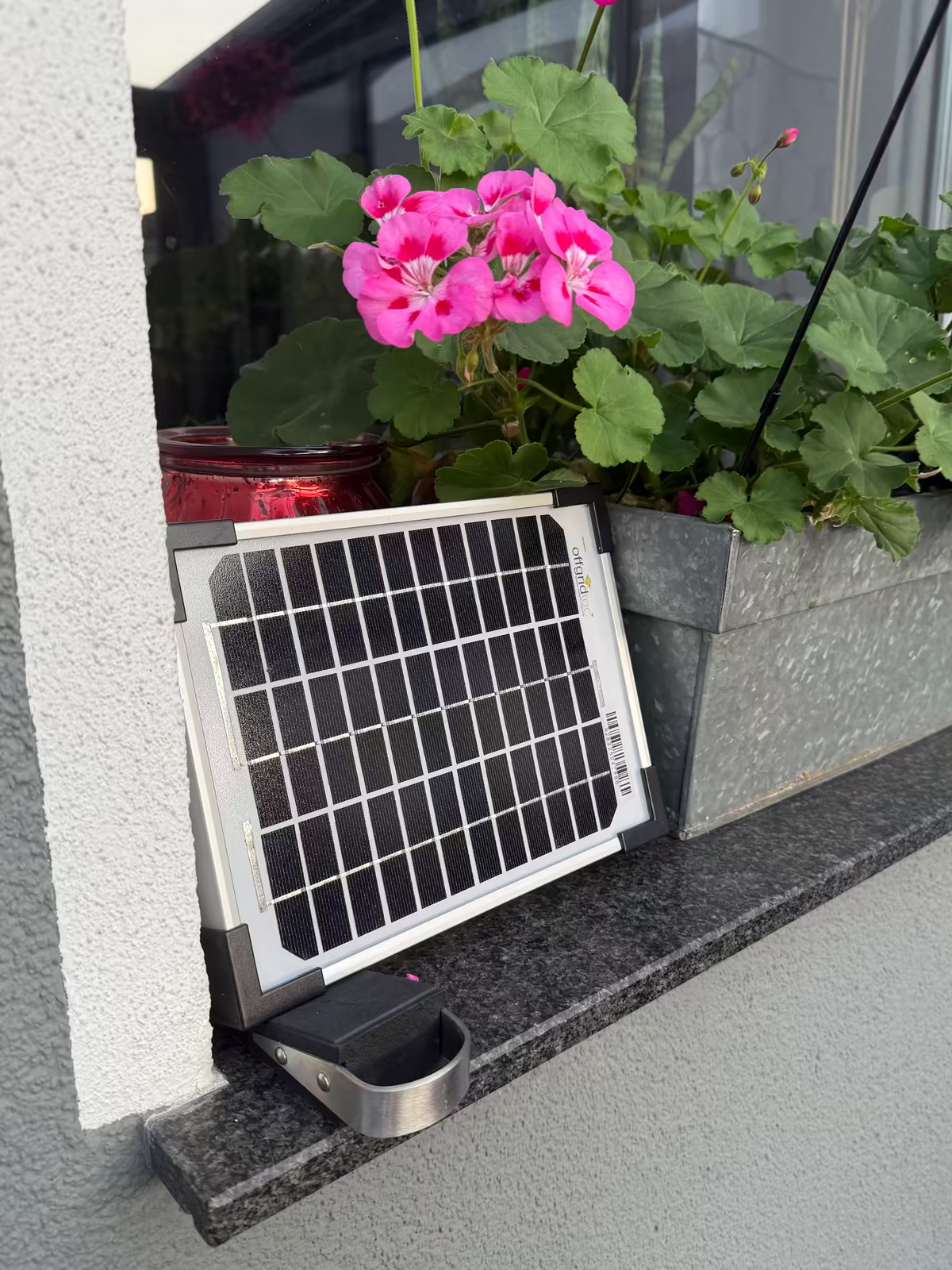 The weather station installed outside my window, with its solar panel in front of it